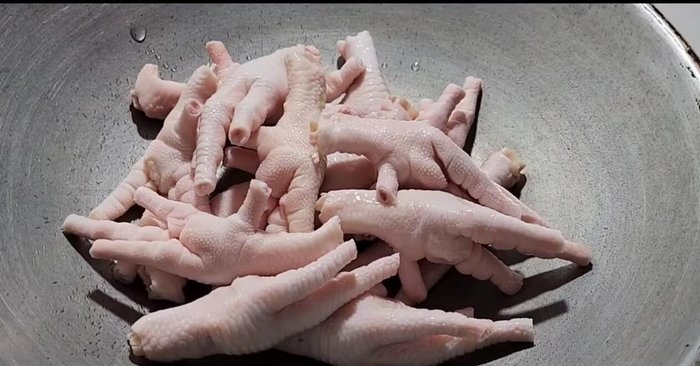 Heat a pan and add the chicken feet.