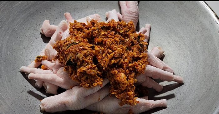 Add the curry paste and stir-fry over medium heat until well blended with the chicken feet.