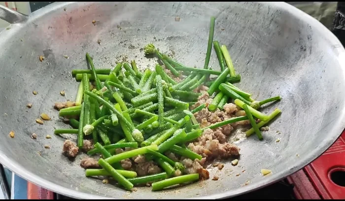 Season with sugar, oyster sauce, and seasoning sauce. Stir-fry until fragrant flowers are cooked.
