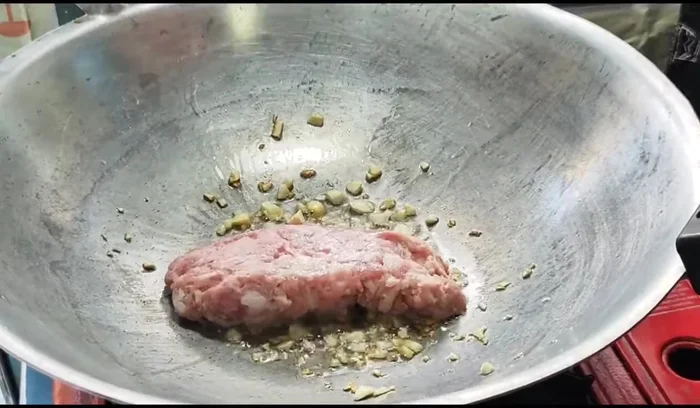 Add minced pork and stir-fry until cooked.
