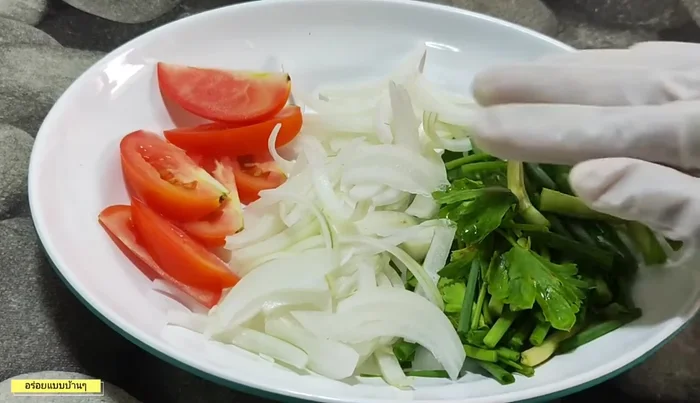 Prepare ingredients: Chop spring onions, onions, and tomatoes. Cut pork roll into bite-sized pieces.