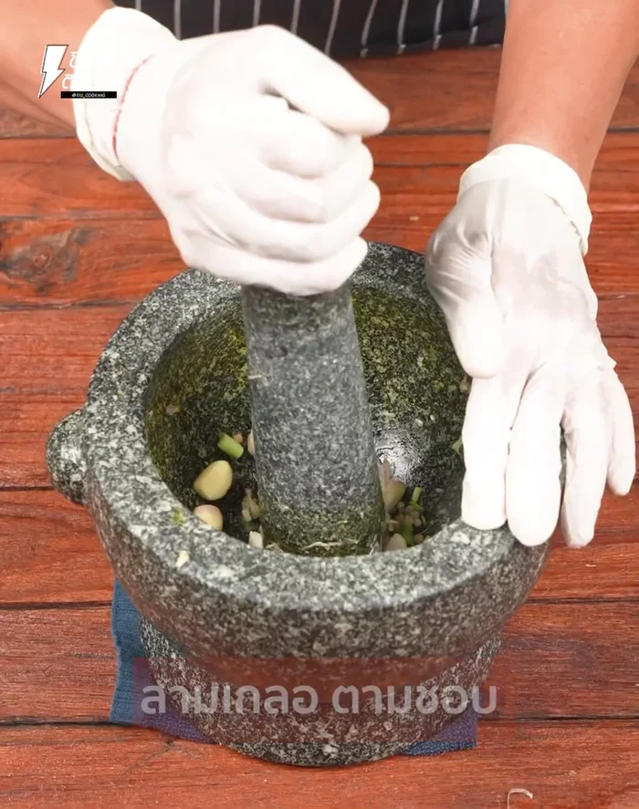 Pound garlic, peppercorns, and chopped coriander in a mortar until fine. (66)