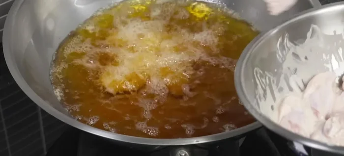 Carefully add the chicken wings to the hot oil, ensuring they are not overcrowded. Fry until golden brown and cooked through (approximately 10 minutes for chicken wings, longer for thicker pieces).
