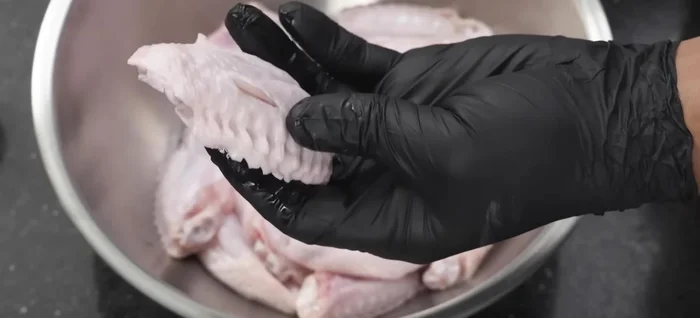 Use a sharp knife to poke holes throughout each chicken wing. This helps the marinade penetrate and cooks the meat faster.