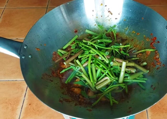 Increase the heat, add the morning glory, and stir-fry until cooked to your desired crispness.