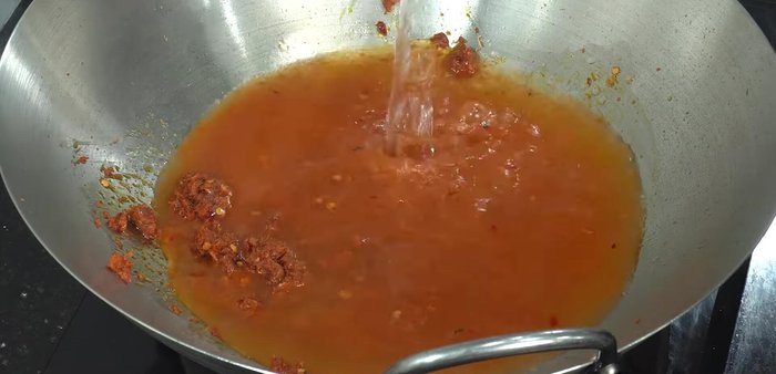 Add 750ml of water to the pan and bring to a boil. Stir until curry paste dissolves.