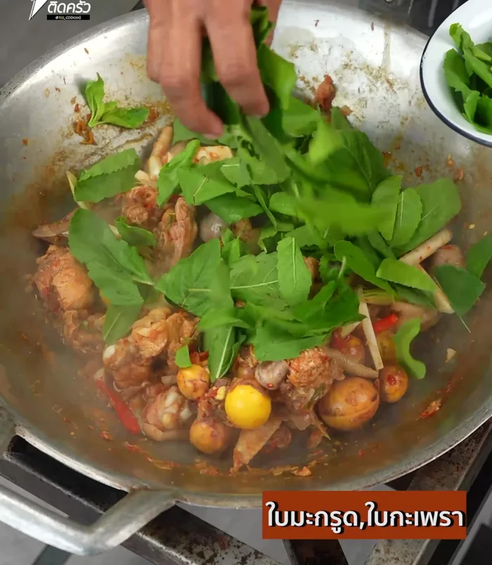 Add kaffir lime leaves and basil leaves. Stir-fry until everything is well mixed.