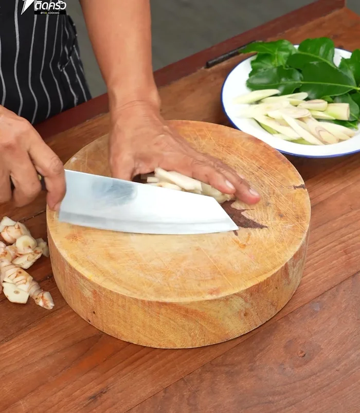 Chop lemongrass, cut galangal into bite-sized pieces, tear kaffir lime leaves from stems and chop into thin strips. Chop lemongrass into small pieces and set aside.