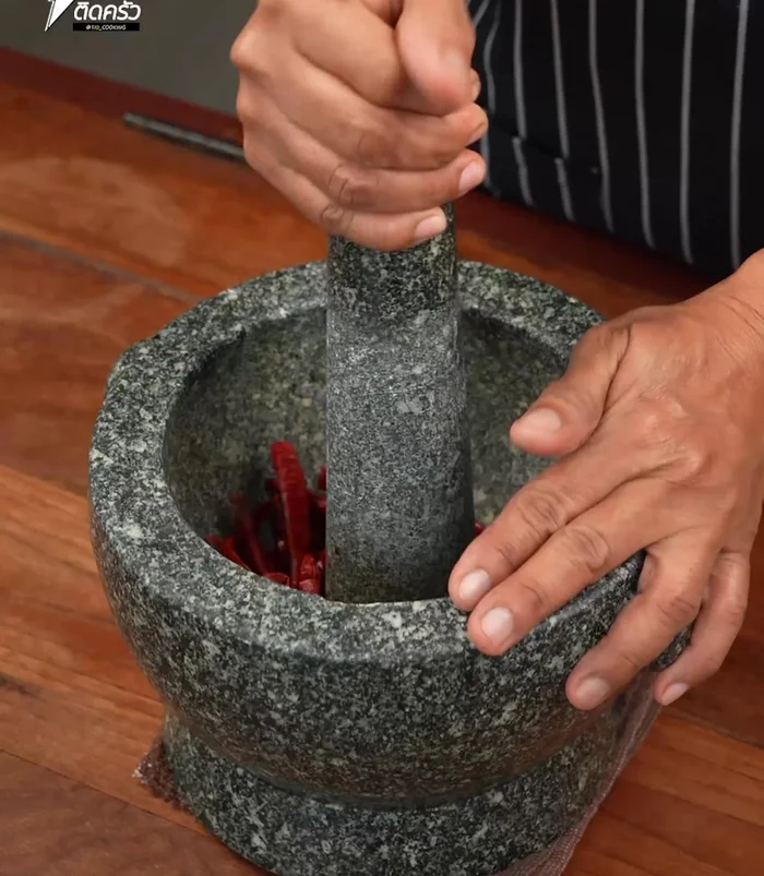 Pound dried chilies in a mortar. Add lemongrass and kaffir lime leaves, pound until finely ground. Add garlic, shallots, and shrimp paste; pound together.