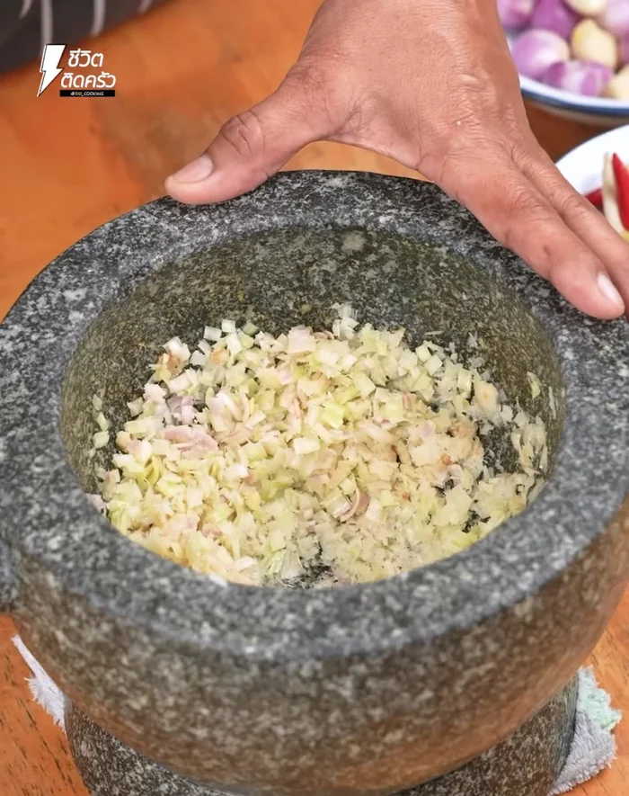 Pound galangal, lemongrass, salt, red chili peppers, turmeric, shallots, and garlic together in a mortar until well mixed.