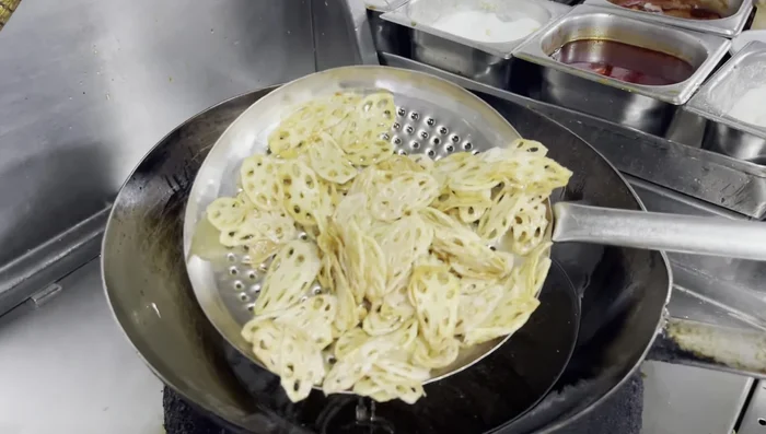 Increase oil temperature to 180°C, then fry the lotus root again until crispy and golden brown. Remove immediately.