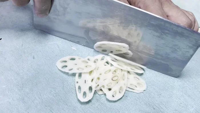 Peel the lotus root and cut it into fine, evenly sized slices. Soak the slices in a bowl of water.