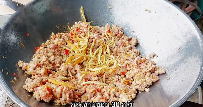 Add the sliced galangal and stir-fry until the pork is cooked and spices are absorbed.