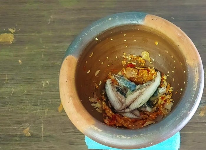 Add the cooked mackerel to the pounded chilies.