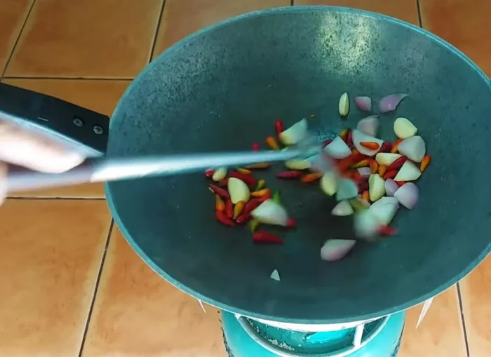 Roast red onion, garlic, and chili peppers until cooked. You can use any type of chili pepper.