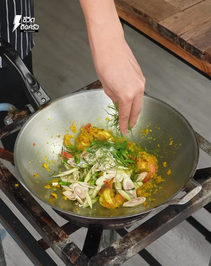 Sprinkle in shredded kaffir lime leaves, stir, and mix everything together.