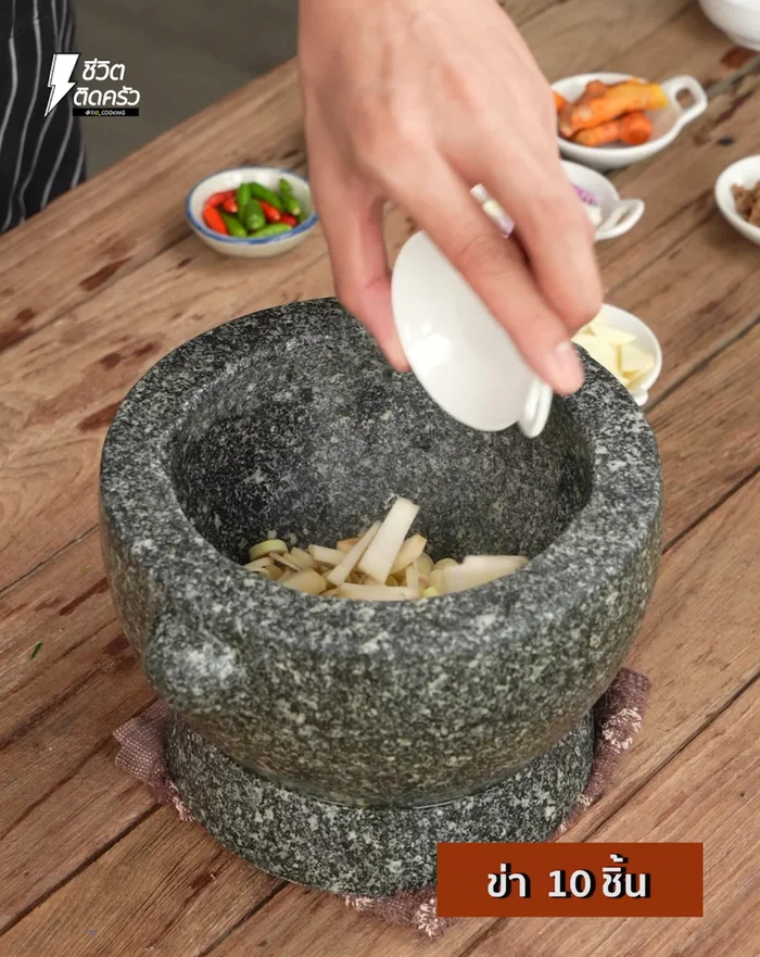 Prepare the curry paste: In a mortar and pestle, pound together sliced lemongrass, galangal, garlic, shallots, turmeric, a little salt, and chili until fine.