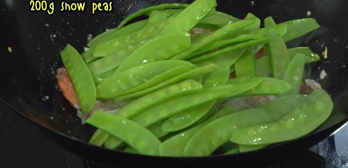 Add snow peas. Pour in the water used to rinse the mortar.