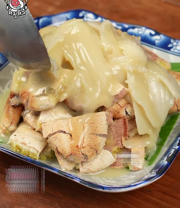 Place the crispy bananas on a plate and pour the thick coconut milk over them until the bananas are covered.