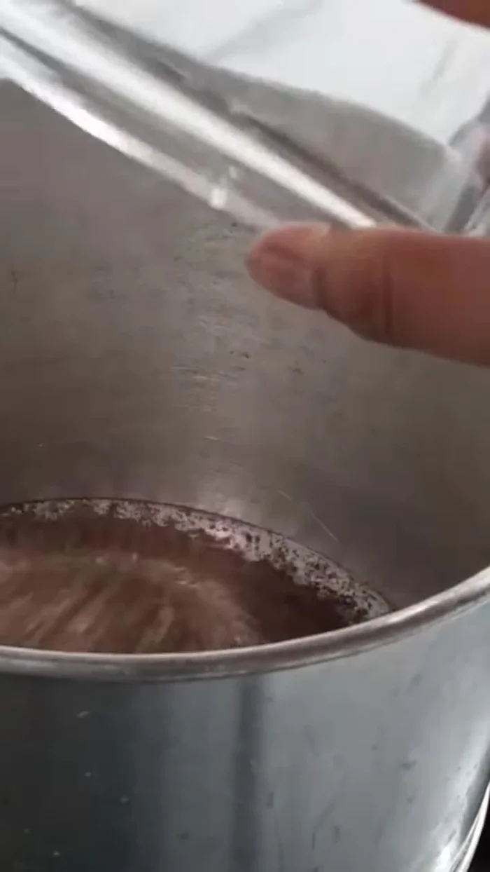 Prepare a pan for cooking. Add 200 grams of granulated sugar, 10 tablespoons of Thai tea powder, and 1500 ml of water.