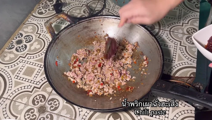 Add roasted chili paste and stir-fry until well mixed with the pork.