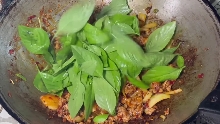 Add basil leaves and stir-fry on high heat until wilted.