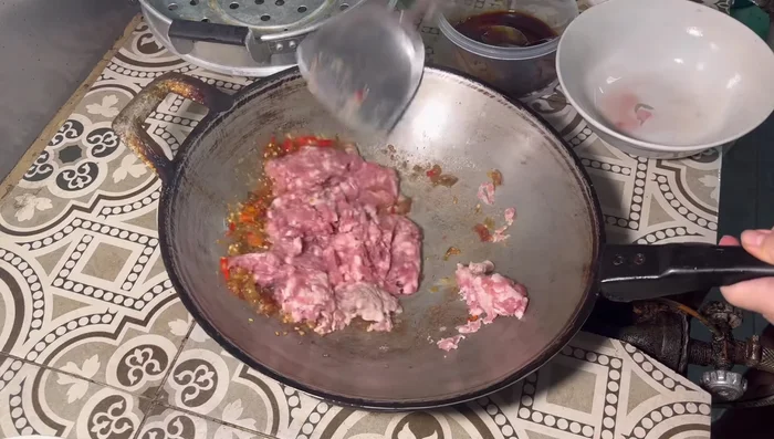 Add the minced pork and stir-fry until cooked.