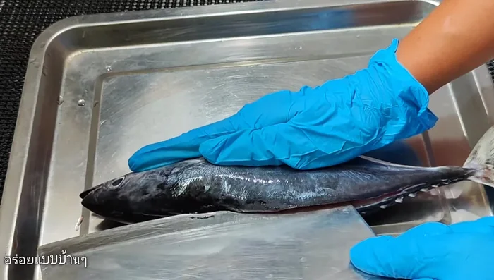 Clean the bonito: Use a sharp knife to cut through the middle of the fish's spine and peel the skin towards the head. Remove the gills and intestines. Rinse the fish thoroughly about 3 times.