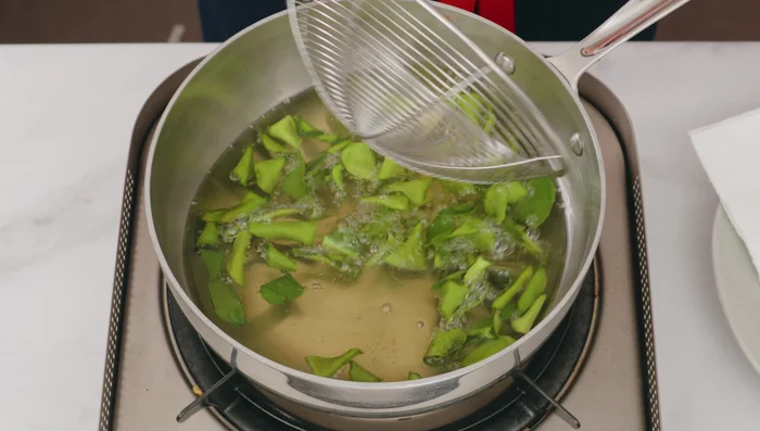 Fry lime leaves and lemongrass: Add lime leaves to the oil and fry until crispy. Remove. Add lemongrass and fry briefly to infuse flavor into the oil; discard lemongrass. (442.639)
