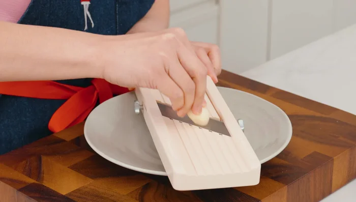 Prep the garlic: Thinly slice large garlic cloves using a mandolin or knife. Spread them out to dry. (76.159)