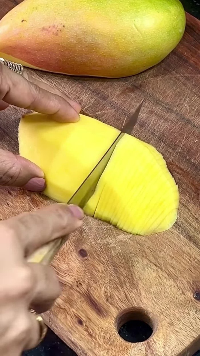 Cut the mango into thin, long slices.