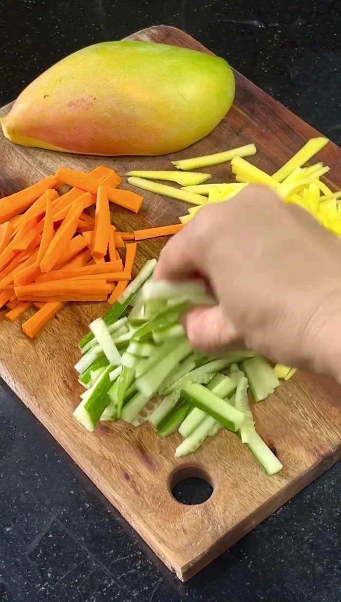 Place the mango, cucumber, and carrot slices on a plate.