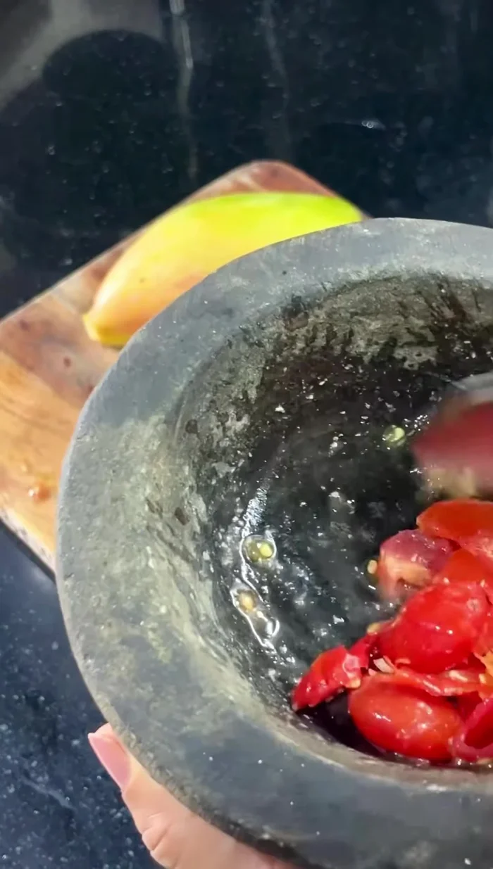 Lightly crush baby tomatoes and add them to the salad.