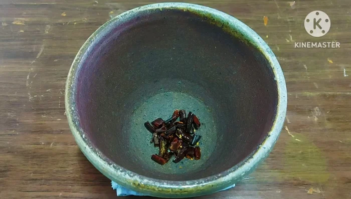 Pound dried chilies in a mortar and pestle until finely ground.