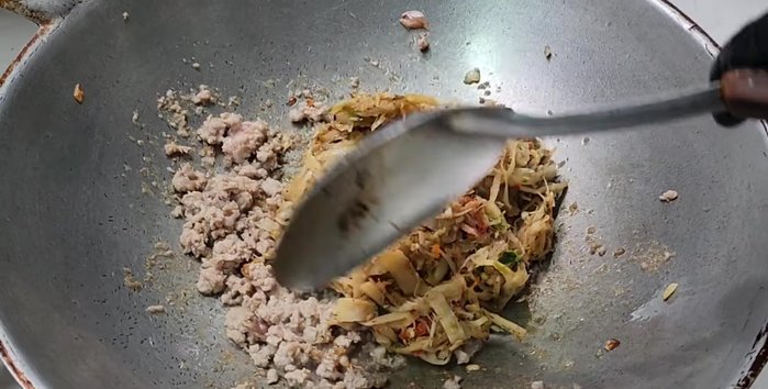 Add the sour bamboo shoot mixture to the pan. Add the water used to rinse the mortar. Stir-fry until dry.