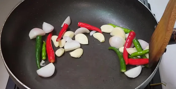 Roast shallots, garlic, and chilies until cooked.