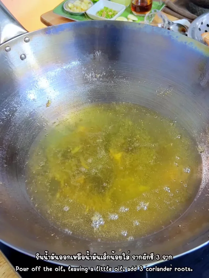 In the same pan, stir-fry coriander roots, crushed garlic, and peppercorns until fragrant.