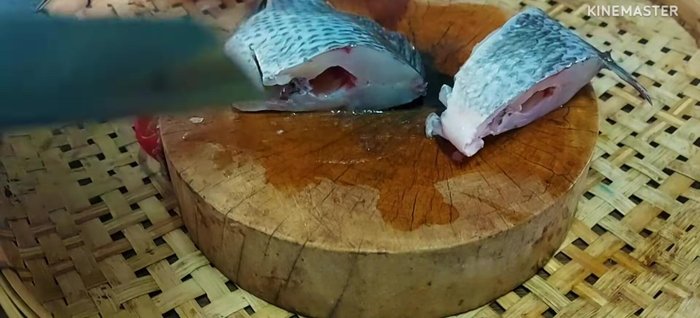 Prepare the tilapia: Cut the fish into pieces. Mae Rung prefers cutting into pieces for better herb blending.