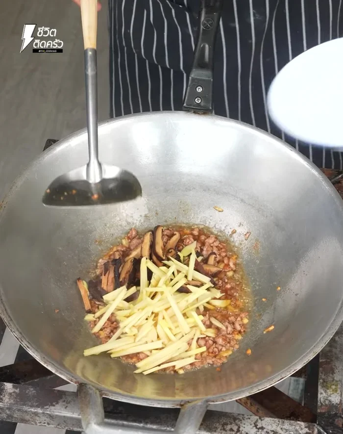 Add the mushrooms and sliced ginger. Stir-fry everything together. Add a little water.
