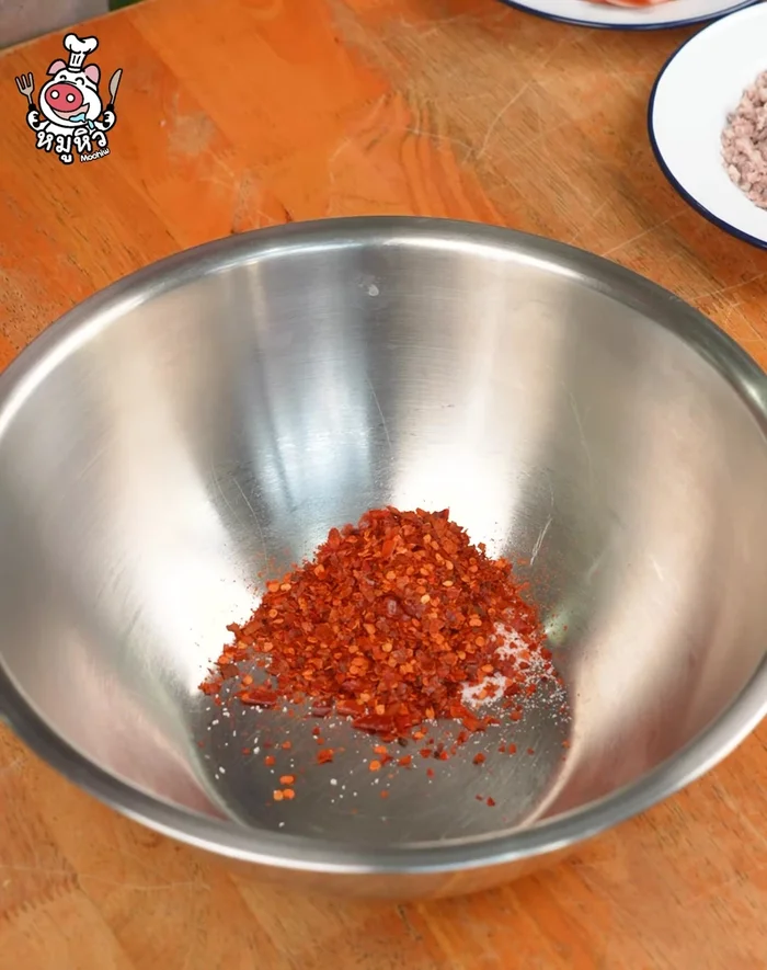 In a bowl, mix Nua powder, chili powder, roasted rice powder, fish sauce, and lime juice.