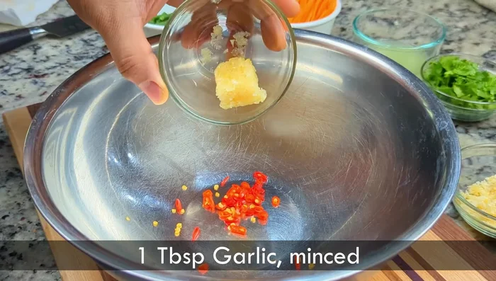 Prepare the dressing: In a mortar and pestle (or bowl), pound chilies, garlic, and shallots into a paste. Add palm sugar, lime juice, tamarind paste, fish sauce (or soy sauce), and salt. Mix well and let rest for 10 minutes.