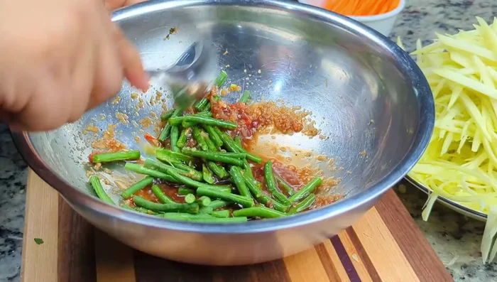 Combine snake beans and dressing, then add cherry tomatoes, pressing gently. Add julienned carrots and mix.