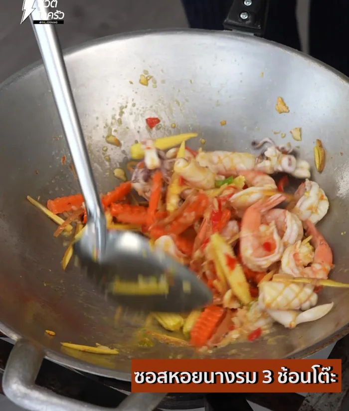 Add carrots, galangal, and corn. Season with oyster sauce, fish sauce, seasoning powder, soy sauce, and sugar. Stir-fry.