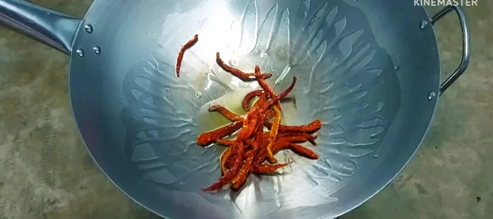 Start making the chili paste: Put dried chilies in a pan and fry them. Add the amount of chilies according to your spice preference.
