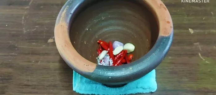 Make curry paste: Finely pound red chili peppers, garlic, shallots, salt, and shrimp paste.