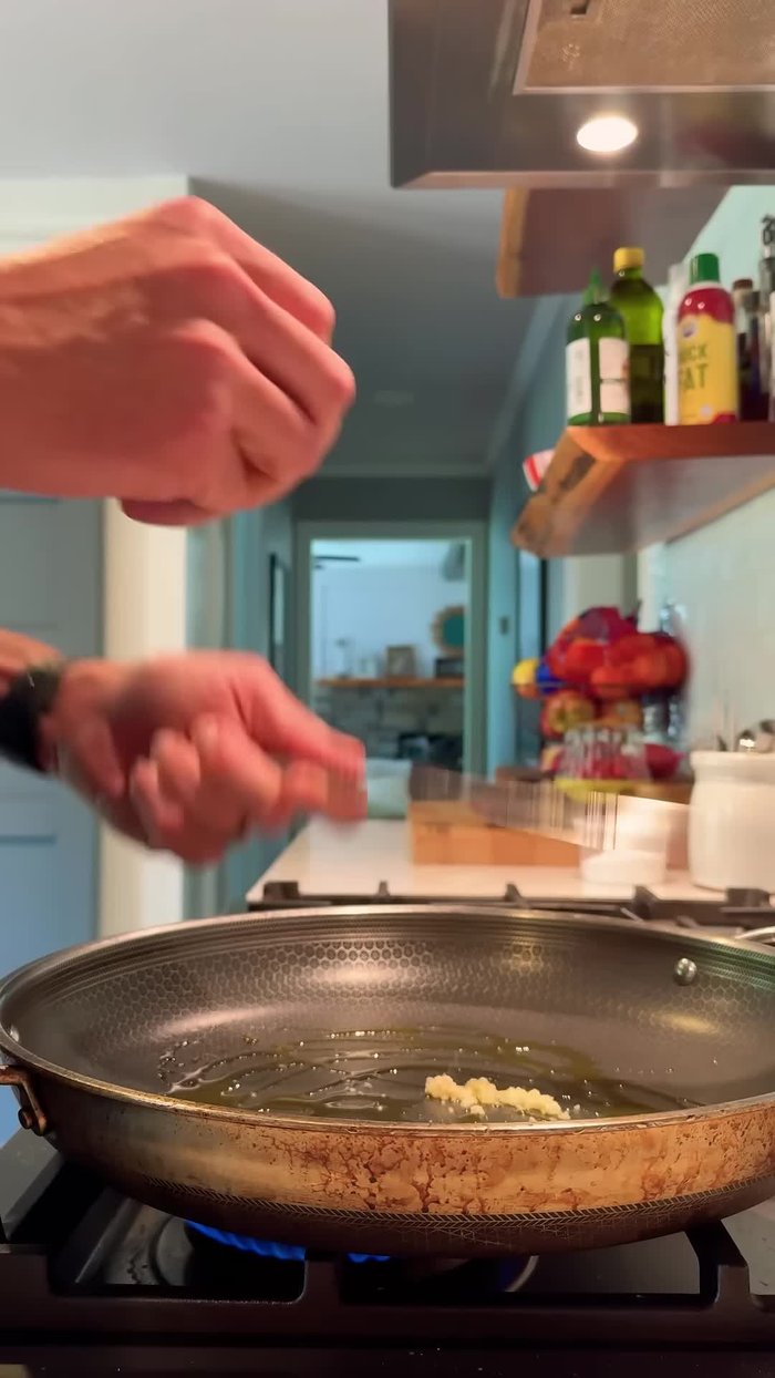 Microplane some garlic into the pot. Add your ground chicken.