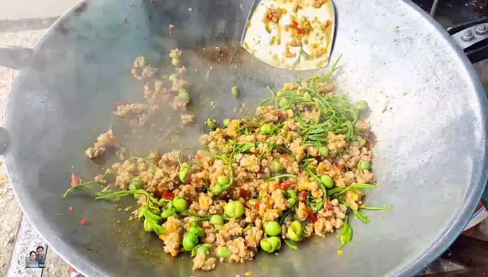 Add 1 gram of cha-om (or more to taste). Stir-fry briefly, as cha-om cooks quickly.