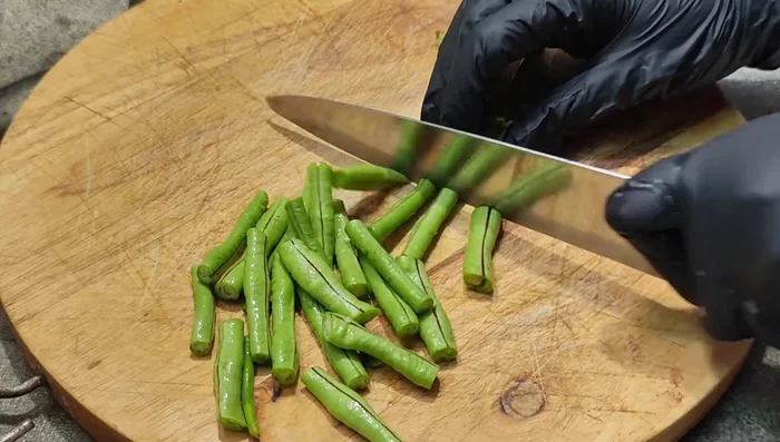Cut yardlong beans into pieces.