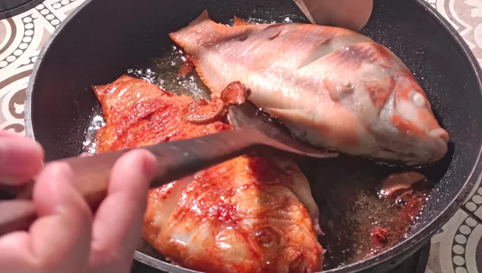 Once the fish is golden yellow on one side, flip it and fry the other side.