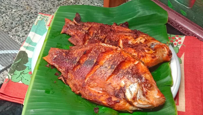 Remove the fish from the pan and place it on a plate to drain excess oil.
